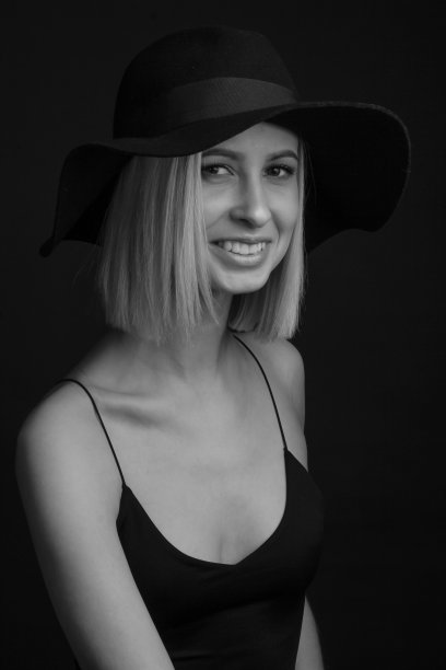 黑色和白色肖像金发在黑色背景的帽子和背心与细带图片下载