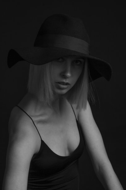 黑色和白色肖像金发在黑色背景的帽子和背心与细带图片下载