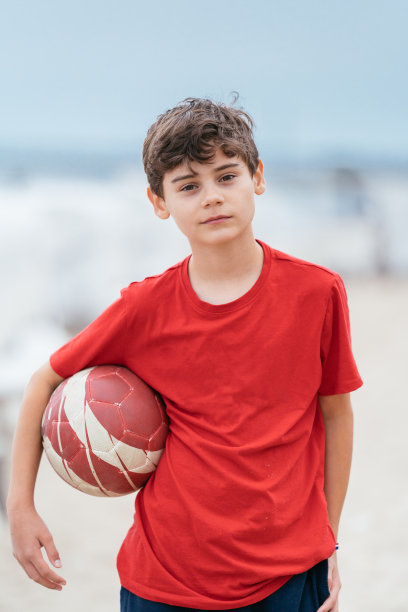 男孩在沙滩上玩球。全家去海边度假图片下载