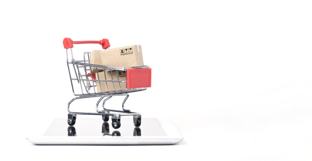 红色购物车手推车内独立的运输纸箱，白色背景和复制空间平板电脑，网上购物和电子商务的概念。图片下载