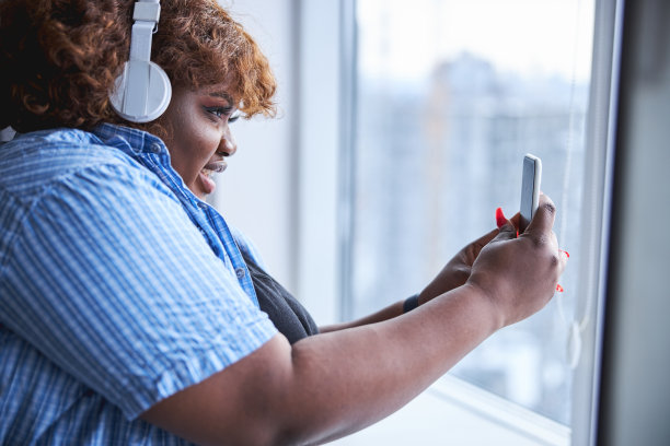 一个迷人的美国黑人女士与智能手机的特写照片图片下载