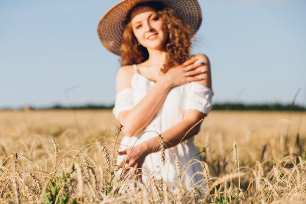 一个长卷发的女孩在麦田里摆姿势图片下载