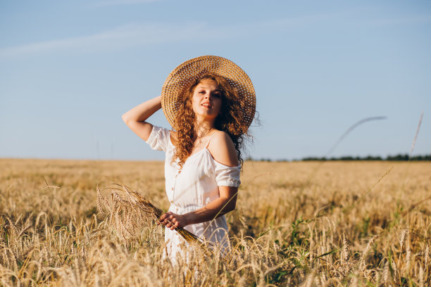 一个长卷发的女孩在麦田里摆姿势图片下载