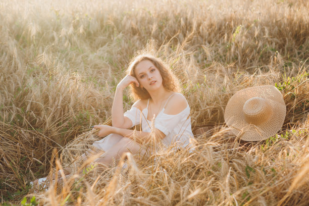 一个长卷发的女孩在麦田里摆姿势图片下载