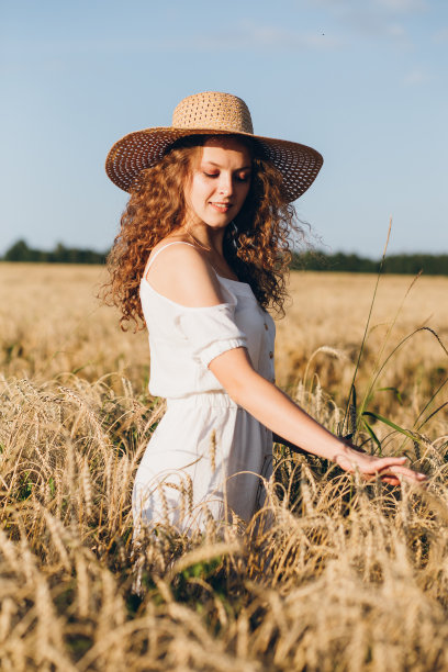 一个长卷发的女孩在麦田里摆姿势图片下载