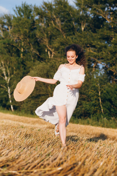 一个长卷发的女孩在麦田里摆姿势图片下载