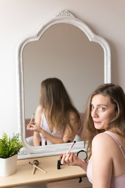 年轻女子在镜子前化妆图片下载