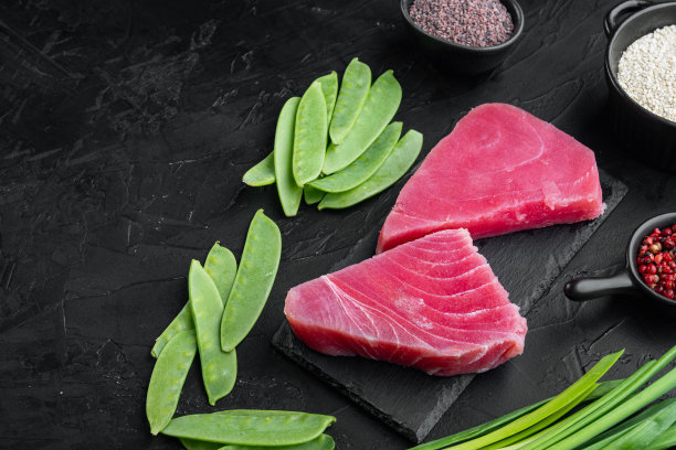 青豆、芝麻、香草等原料的生金枪鱼片，放在石板上，黑色的石头背景上，有文字空间和文字空间图片下载