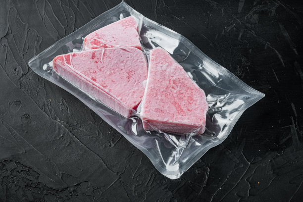 冷冻金枪鱼片在真空包装，在黑色的石头背景，与copyspace和文字空间图片下载