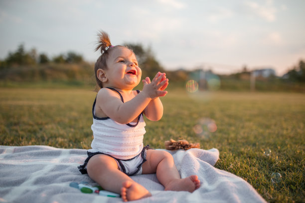 微笑的小女孩在公园里玩肥皂泡图片下载
