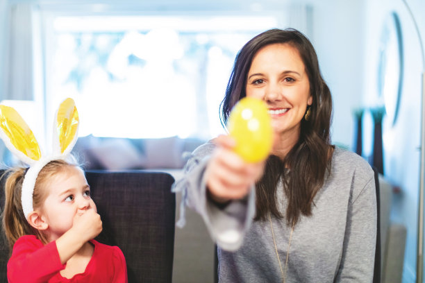 儿童和千禧一代的母亲准备复活节彩蛋和糖果室内狩猎有趣的照片系列图片下载