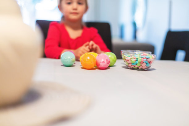儿童和千禧一代的母亲准备复活节彩蛋和糖果室内狩猎有趣的照片系列图片下载