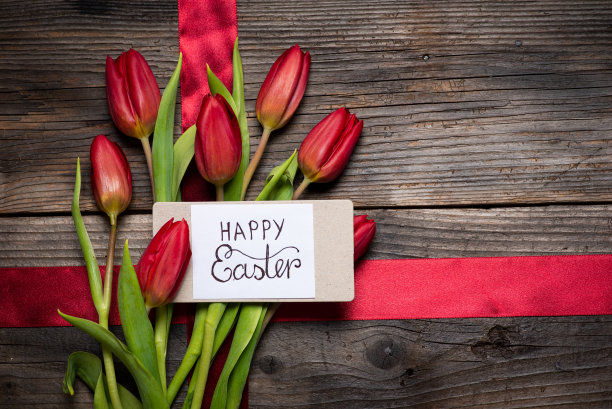 红色的郁金香花束在一张木桌上平躺着图片下载