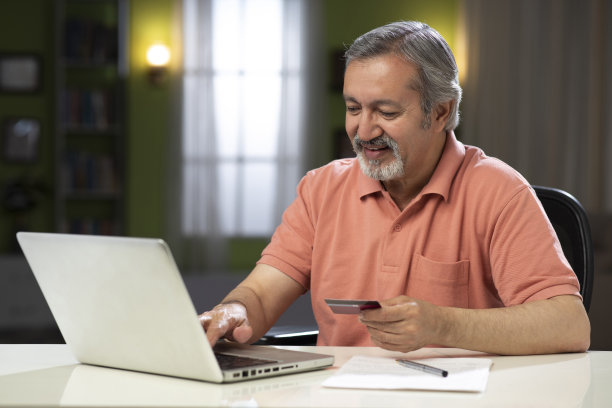 一个成熟男人坐在家里的椅子上的照片:-库存照片图片下载