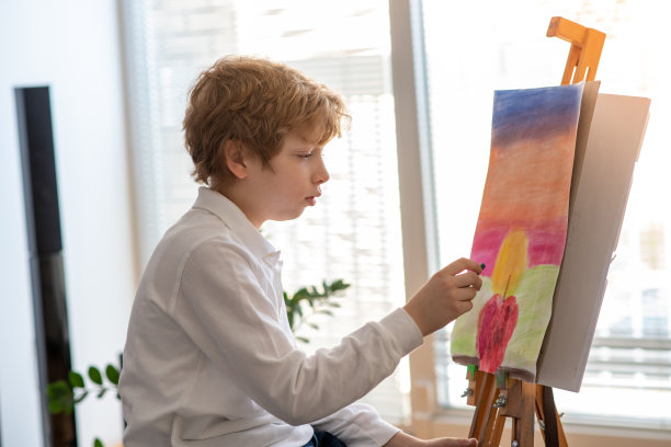 男孩正在为美术课用彩色粉笔画画。图片下载