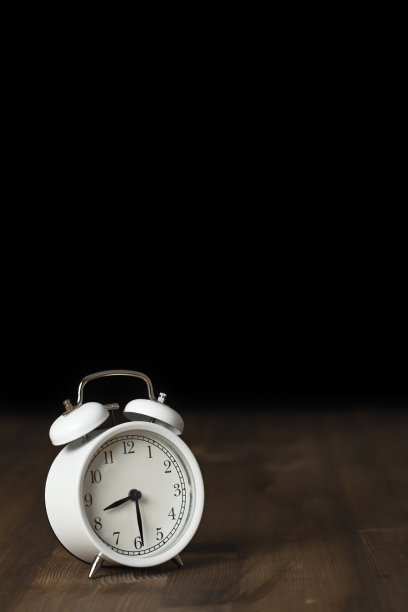 木制背景上的复古闹钟。回到工作和学校的概念。图片下载