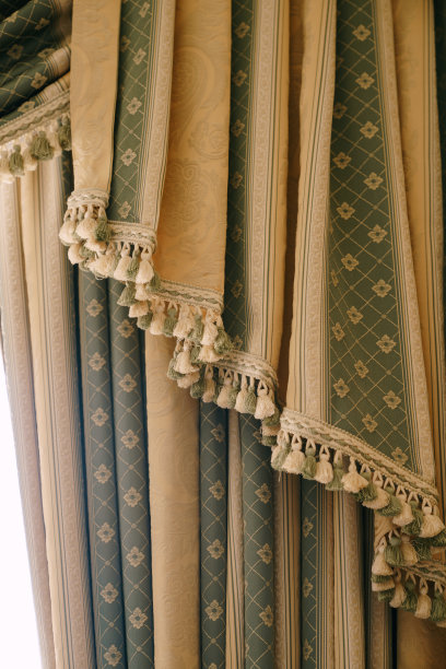 昂贵的绿色和金色窗帘，配有铃铛。酒店的花流苏窗帘。图片下载
