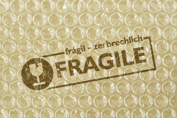塑料气泡膜背景上的“易碎”字样——保护性包装解决方案的概念图片下载
