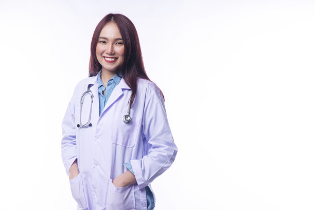 年轻的职业女医生穿着大衣制服，听诊器看着相机，微笑着站在孤立的白色背景。健康保健和保险理念。图片下载