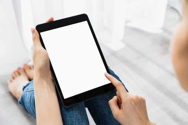 女人手里拿着数字平板电脑，屏幕是空白的。为您的广告复制空间。图片下载