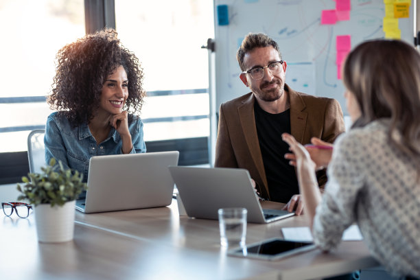 几岁以上的商务人士在办公室里一边用笔记本电脑工作一边谈论他们的新项目。图片下载