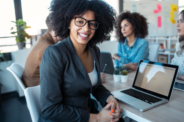 几岁以上的商务人士在办公室里一边用笔记本电脑工作一边谈论他们的新项目。图片下载