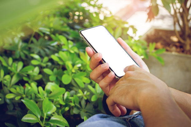 特写人物的手触摸着带有Mockup的智能手机，白色咖啡店里的黑屏。户外图片下载