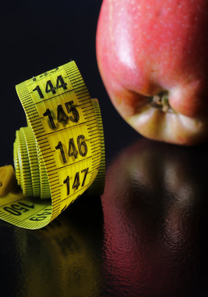 苹果和卷尺在黑色背景图片下载