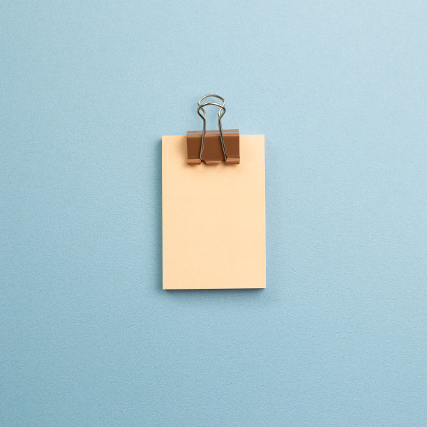 空白备忘录垫与金属夹天蓝色背景。俯视图，复制空间图片下载