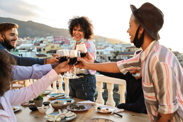 在新冠肺炎疫情期间，年轻的多种族朋友们在户外喝着酒、吃着饭——关注中心女性图片下载