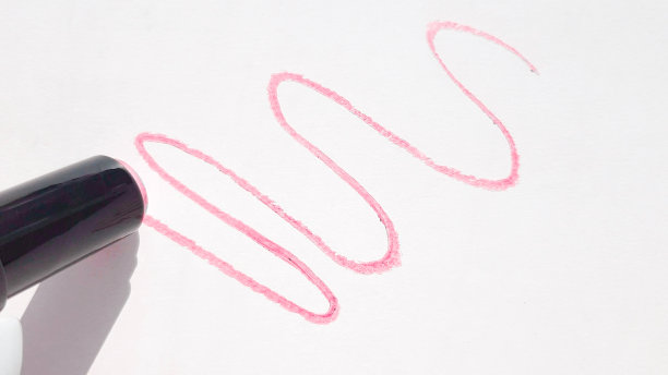 红色口红在白色背景上有波浪纹的图案，口红管的阴影图片下载