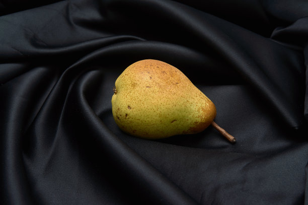 黑暗背景下的绿梨的静物。图片下载