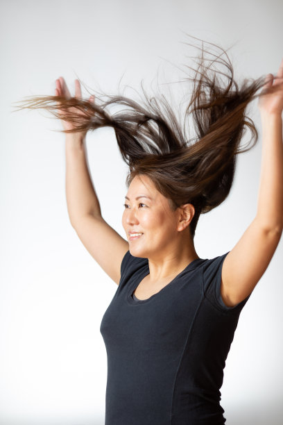 举起双臂，头发飞扬的女性图片下载