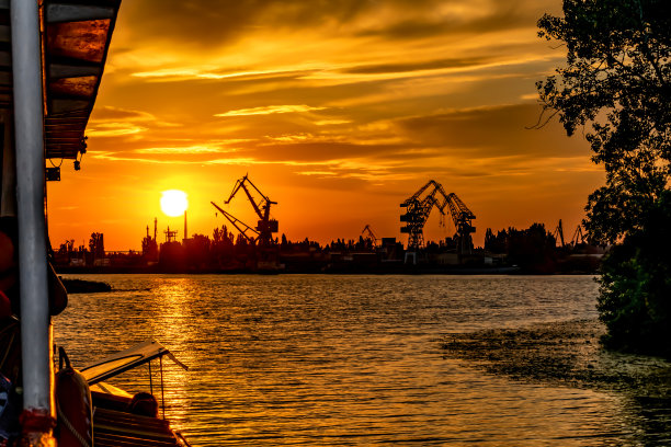 克森(乌克兰)的海岸线剪影和码头上的港口起重机在夕阳的橙色光线中图片下载