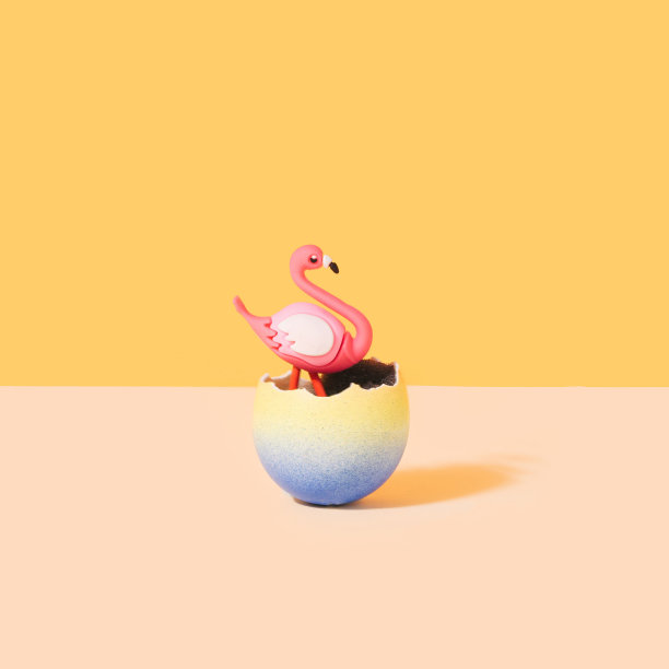 复活节超现实主义的概念。蛋壳里的火烈鸟。橙色和香槟色背景。图片下载