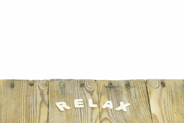 组成单词的字母放松在木质底座上，部分背景为白色，插入文本或图像。用于复制和文本的空间。水平位置。有选择性的重点图片下载