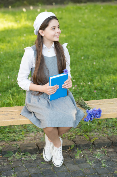 优雅的女学生带着书在公园里，经典的文学理念图片下载