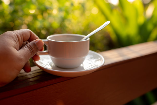 早晨手持咖啡杯在绿色自然的散景背景下，咖啡饮料为新鲜的生活方式，靠近杯子和蒸汽水在阳光墙纸的光，美丽的照片为图形创意图片下载