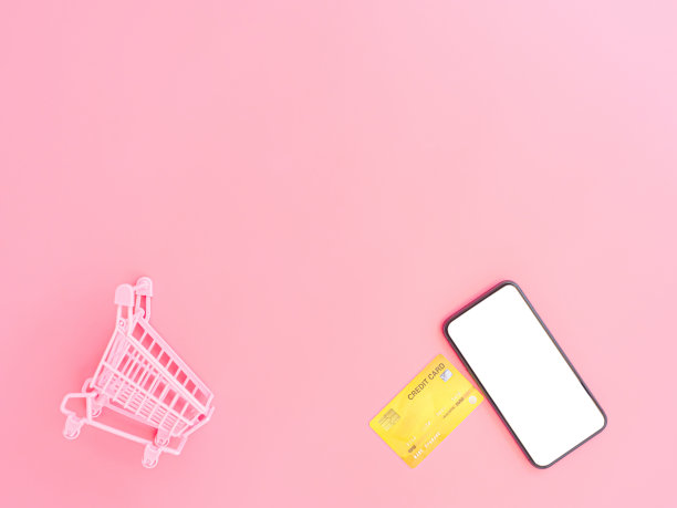 购物和网上支付概念从粉色钱包，信用卡，购物车和粉色粉彩背景上的空白智能手机。图片下载