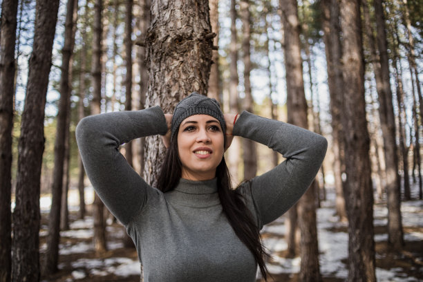 森林里的年轻女子。女人在大自然中旅行。一个快乐的成年游客在大自然中享受乐趣。休闲服饰，松树林中的女人。周末的活动。图片下载