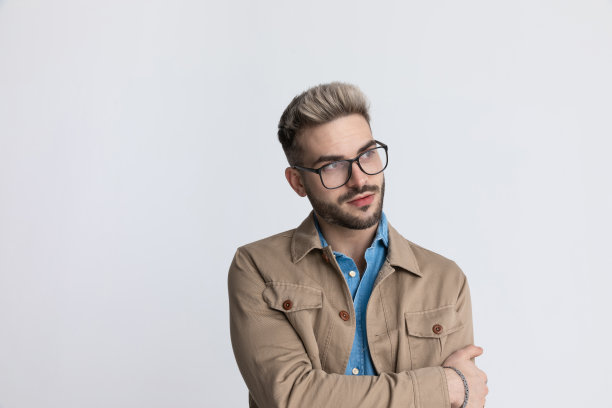 聪明的年轻人随意看向一边，以时尚的姿势挽着手臂图片下载