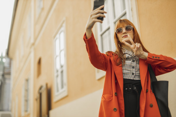一位年轻女士在街上用手机图片下载