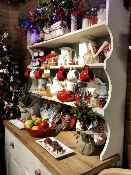 木制梳妆台的形象，货架显示圣诞相关的物品，塑料水果碗，悬挂红白杯子，装饰花环，出售图片下载