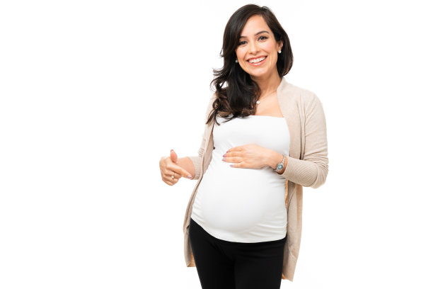 漂亮的女人微笑着指着她怀孕的肚子图片下载