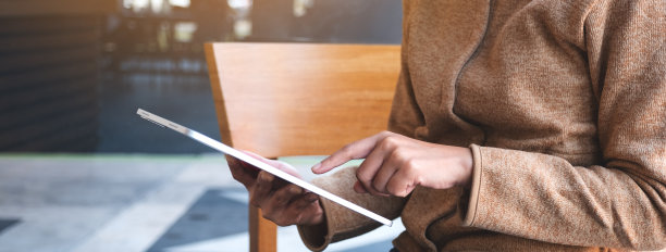 一个拿着并使用数码平板电脑的女人图片下载