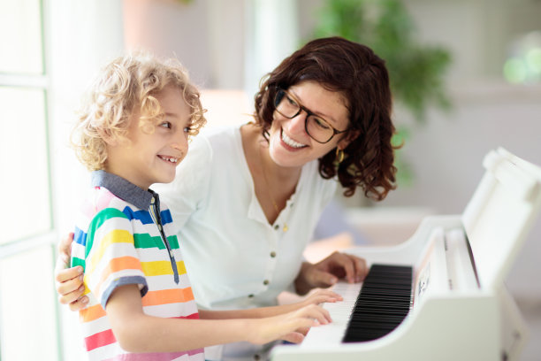 孩子弹钢琴。孩子们演奏音乐。图片下载