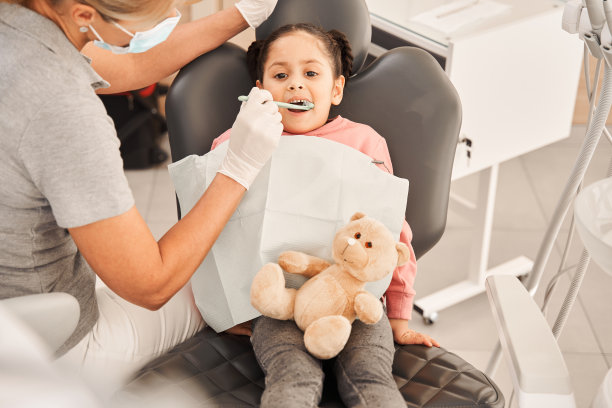 牙医正在给她的小女孩病人洗牙图片下载