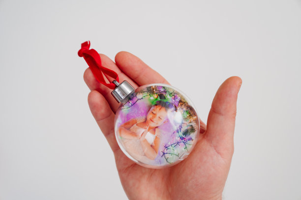 圣诞树玩具球和孩子女孩的照片在手里图片下载