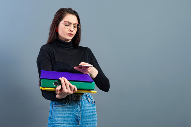 女性拿着智能手机，拿着装满文件的文件夹，在黑暗的背景下孤立图片下载