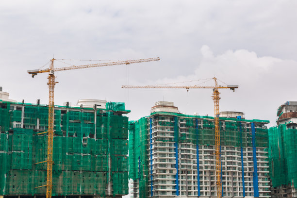 一幢正在施工的建筑周围有安全网。正在建造高楼。图片下载